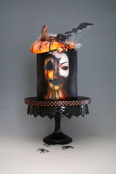 a halloween cake decorated with an image of a woman and bats on the top tier