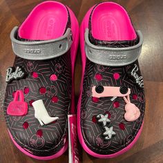 a pair of black and pink shoes on top of a wooden floor with magnets