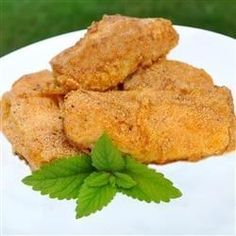 some fried food on a white plate with green leaves