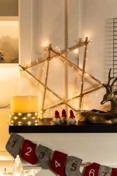 a mantle with christmas decorations and lights on it