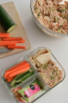 there are many different food items in the container on the table, including carrots and celery