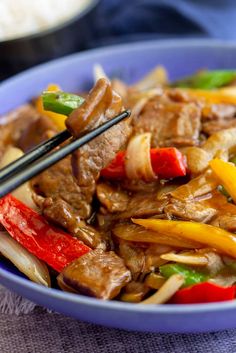 a blue bowl filled with meat and vegetables