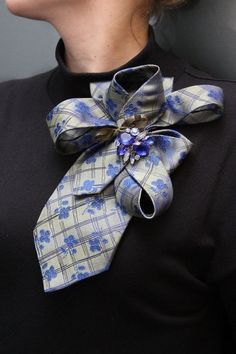 a woman wearing a black shirt with a blue and white flower on it's neck