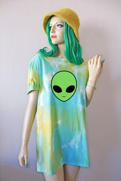 a mannequin wearing a green alien t - shirt and yellow hat with her hands in the air