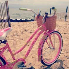 two bikes with baskets on the front and back parked next to each other at the beach