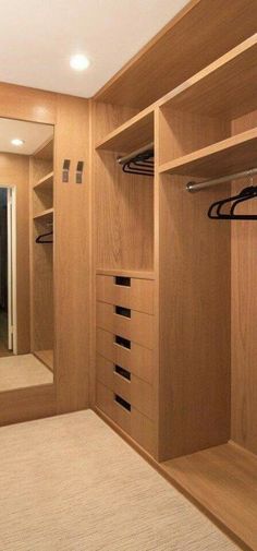 an empty walk - in closet with wooden shelves and drawers