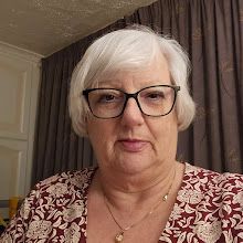 an older woman with glasses is looking at the camera while wearing a red and white shirt