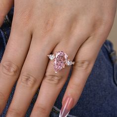 a woman's hand with a pink diamond ring on top of her left hand