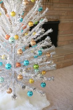 a white christmas tree with multicolored ornaments