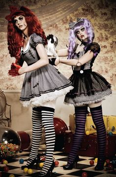 two women dressed in costumes standing next to each other on a checkerboard floor