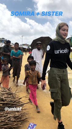 a woman walking down a dirt road with people behind her and the caption somma + sister