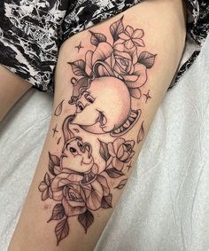 a woman's thigh with flowers and an elephant tattoo on the side of her leg