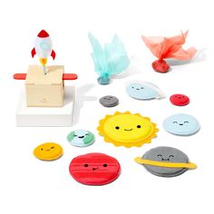 an assortment of magnets and toys on a white surface, including a toy rocket