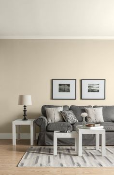 a living room with couches, tables and pictures on the wall in it's corner