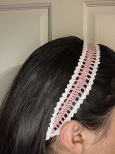 a woman wearing a pink and white crocheted headband with two rows of stitches