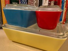 two plastic containers with red and blue dips in them sitting on top of a shelf