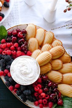 a platter filled with fruit, crackers and dip