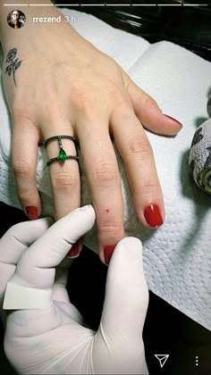 a woman getting her nails done with a manicure by a man in white gloves