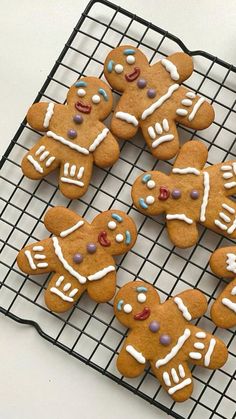 several decorated ginger cookies on a cooling rack