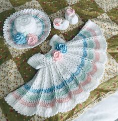 a crocheted baby dress and hat on a quilt