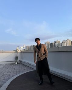 a man standing on top of a roof next to a tall building with buildings in the background