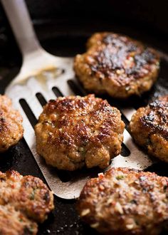 some meat patties are cooking in a skillet