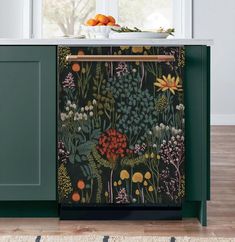 a dishwasher sitting on top of a green cabinet next to a window with flowers