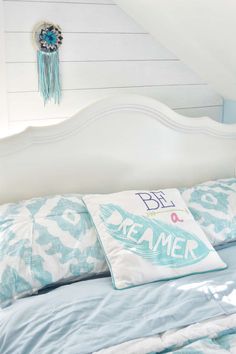 a bed with blue and white pillows on top of it