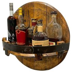 a wooden barrel shelf with bottles and liquors on the bottom, in front of a white background