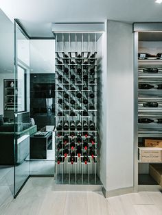 a wine rack in the middle of a room with glass doors and shelves filled with bottles