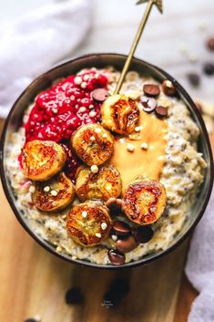 a bowl filled with oatmeal topped with bananas and other toppings next to a spoon