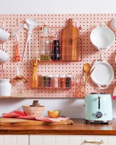 a kitchen counter topped with lots of white plates and utensils on a pegboard