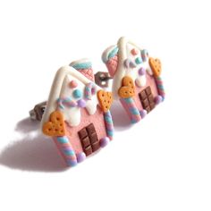 two pink and white earrings with candy houses on them