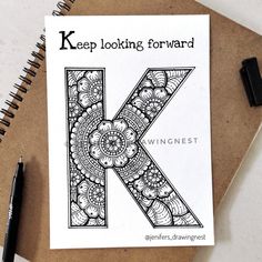 the letter k is made up of intricately designed designs and has been drawn in black ink