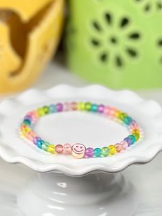 Everyone can use a little dose of happy and, to be honest, it’s hard not to smile back at these cute little stretch bracelets. Need a little mood boost? Just glance at your wrist! Glass beads frame a single enamel in metal smiley face. She measures about 7 inches around. If you need a different length, please just let us know. Adjustable Rainbow Beaded Bracelets Playful Style, Adjustable Rainbow Beaded Bracelets, Playful Style, Adjustable Rainbow Beaded Bracelets In Playful Style, Cheerful Adjustable Multicolor Friendship Bracelets, Fun Adjustable Rainbow Beaded Bracelets, Adjustable Rainbow Beaded Bracelet For Fun, Cheerful Adjustable Friendship Bracelets As Gift, Cheerful Multicolor Adjustable Friendship Bracelets, Adjustable Multicolor Hypoallergenic Stretch Bracelet