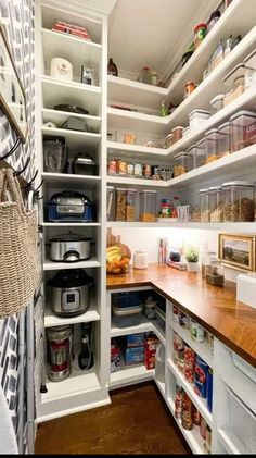 an organized pantry with wooden counter tops and shelves filled with containers, baskets, and other items