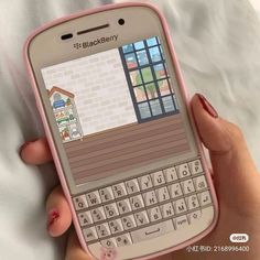 a hand holding a pink blackberry phone with an image of a house on the screen