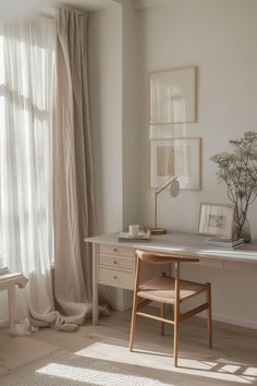 a white desk and chair in front of a window with sheer drapes on the windowsill