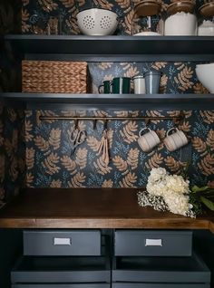 the shelves in this kitchen are filled with pots, pans and utensils