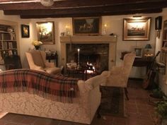 a living room filled with furniture and a fire place in the middle of it's wall