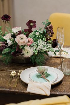 the table is set with flowers and place settings