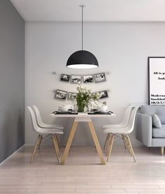 a dining room table with chairs and a couch in front of it, along with pictures on the wall