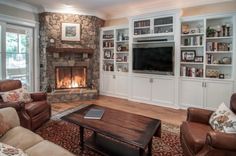 a living room filled with furniture and a fire place in front of a tv mounted on a wall