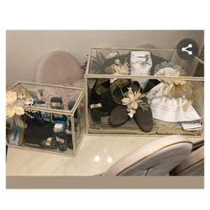 two clear boxes filled with different types of shoes and other items sitting on top of a table