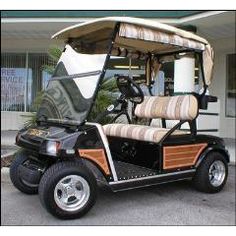 a golf cart parked in front of a building with the door open and seat up