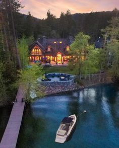 an aerial view of a house with a dock in the foreground and boats on the water