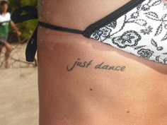 a woman with a tattoo on her stomach saying just dance