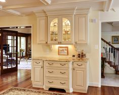 a large kitchen with wooden floors and white cabinets in the middle of an open floor plan