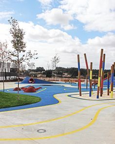 an empty playground with colorful play equipment and trees