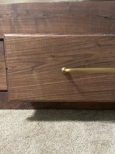 a close up of a drawer on the floor with carpet in the room behind it